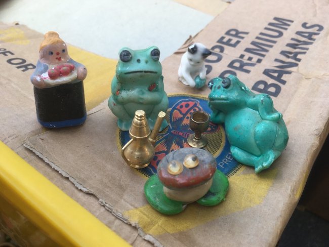 small frog, cat and human figurines gathering, conversing, plotting